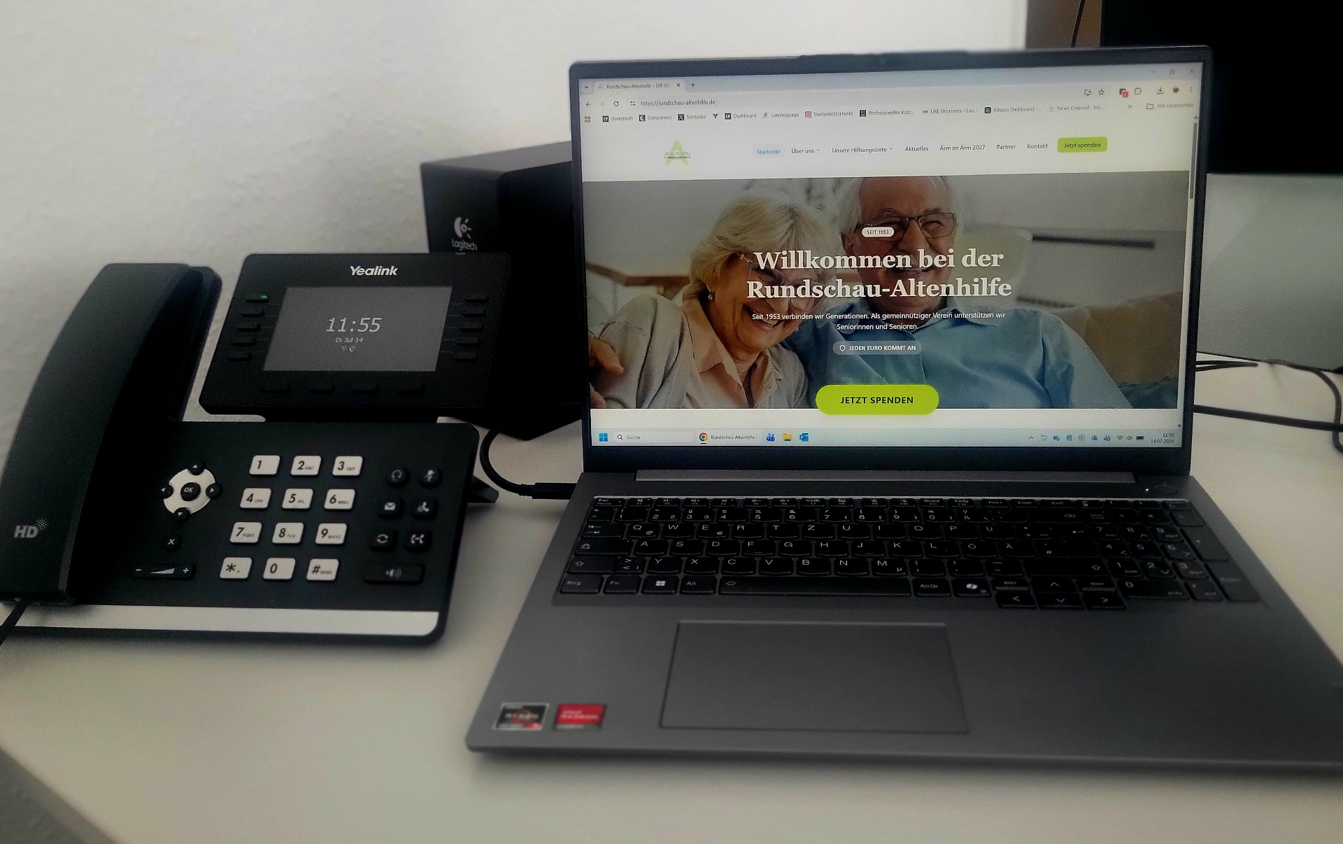 Laptop mit der Antragsseite der Rundschau-Altenhilfe und Telefon auf einem Schreibtisch